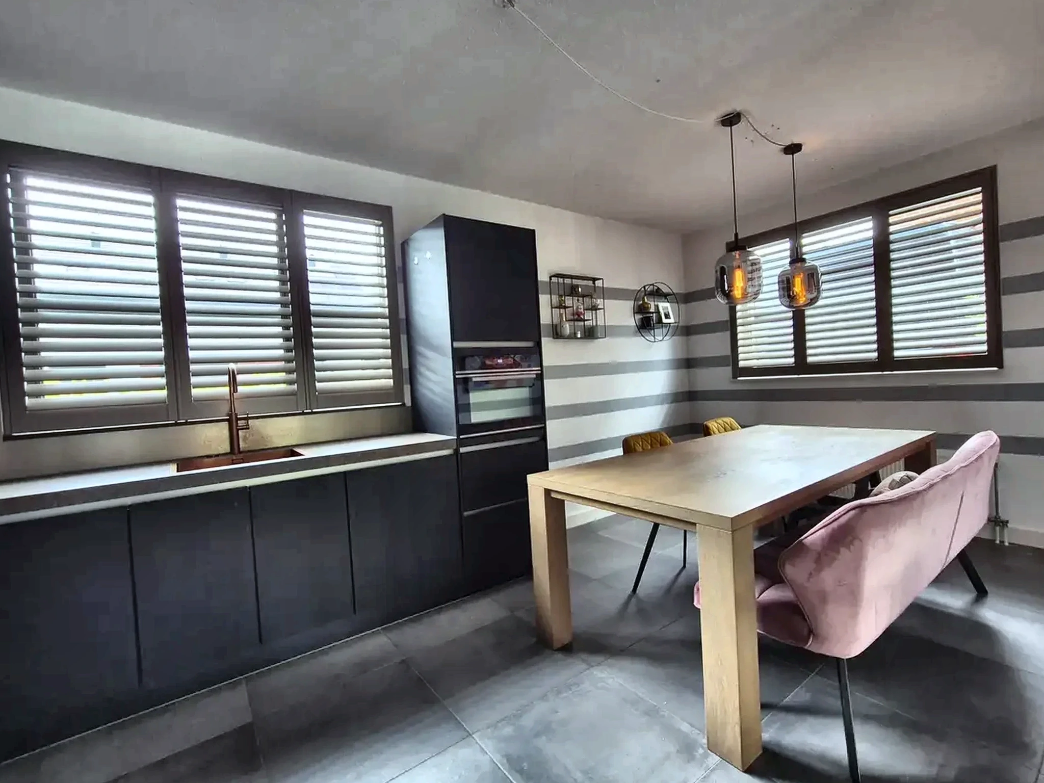 Lichte houten shutters in een keuken en eetruimte
