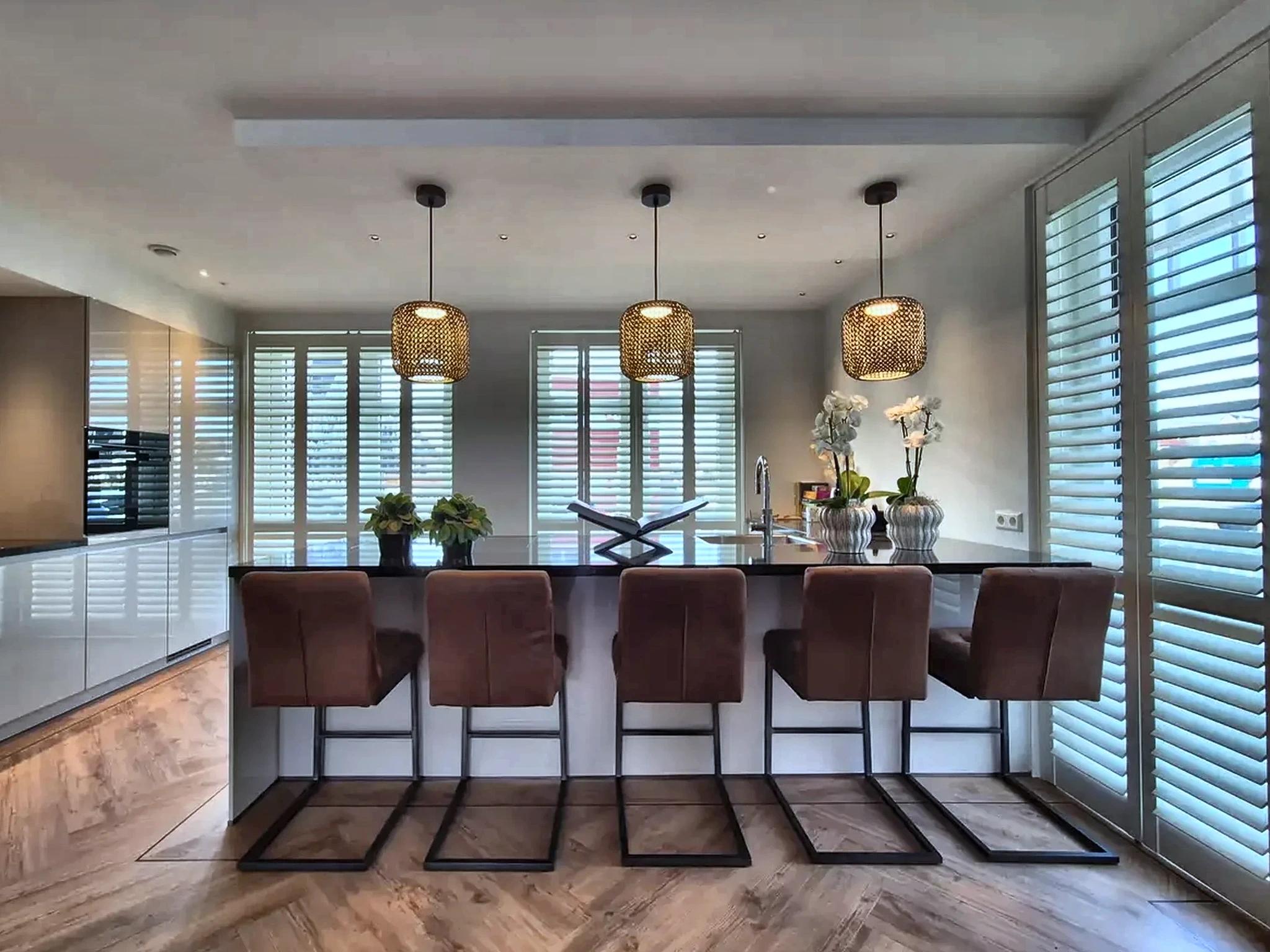 Witte houten shutters rondom een kookeiland