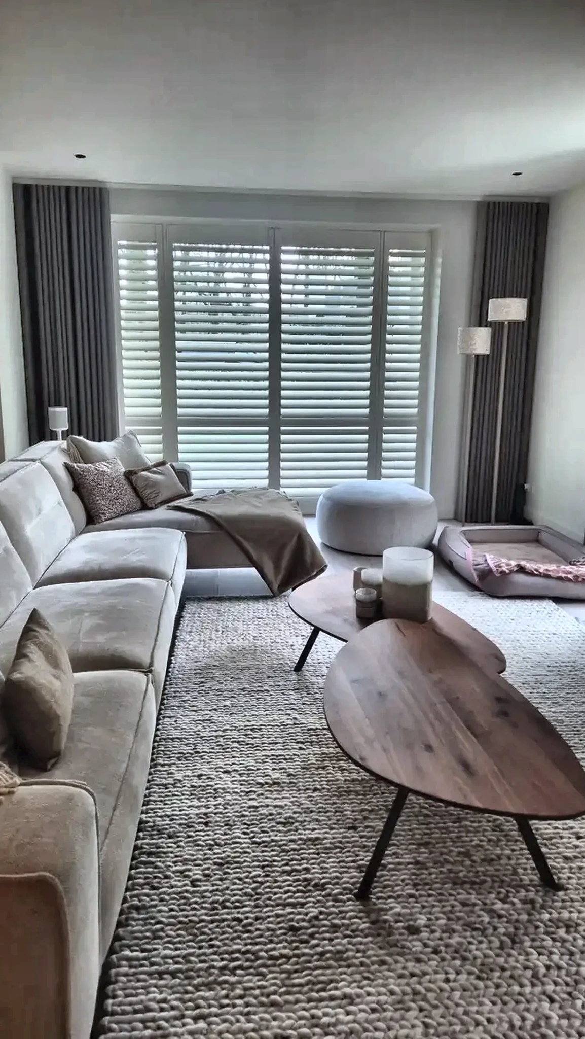 Hoge witte houten shutters in een rustige woonkamer