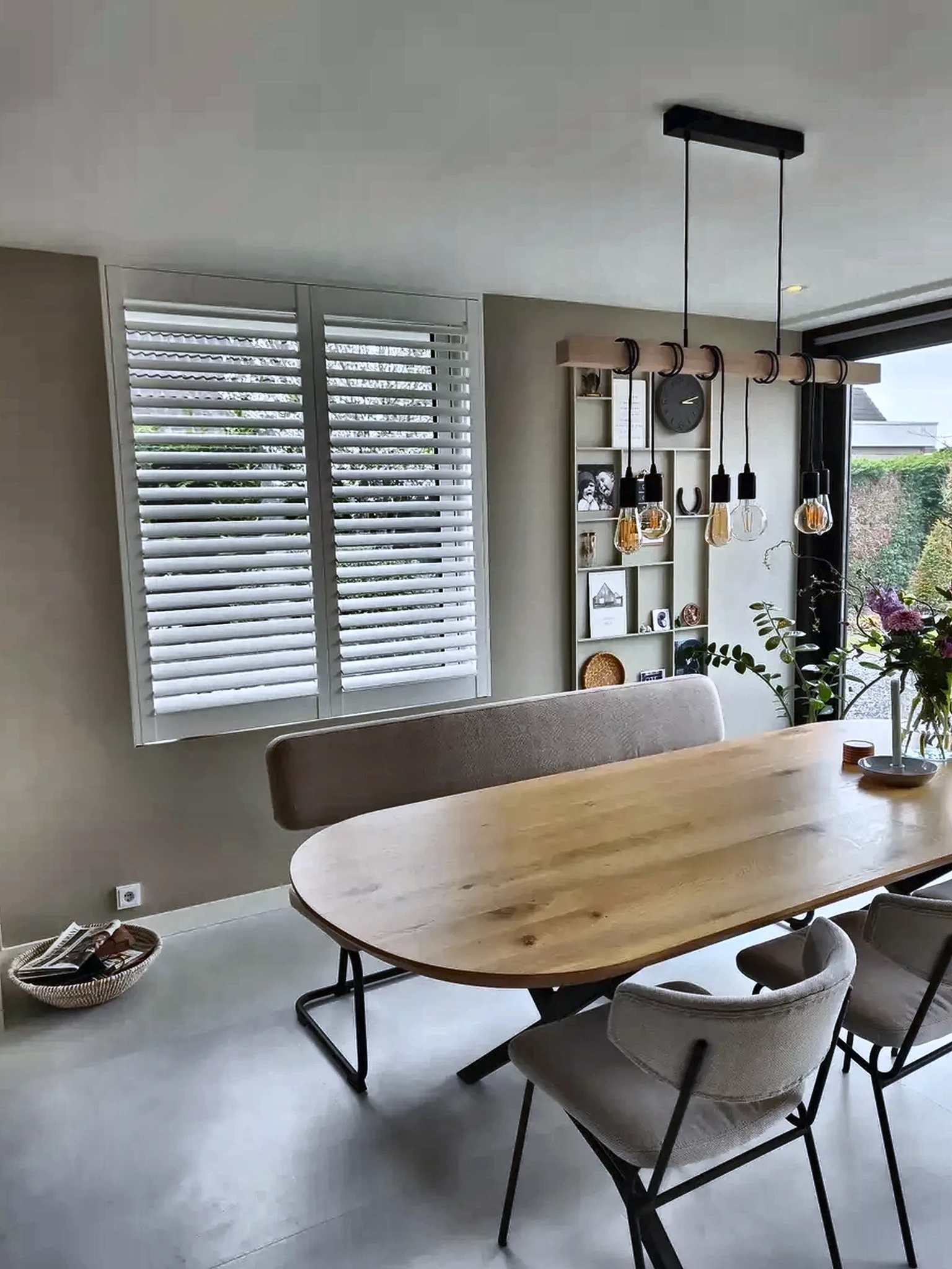 Witte houten shutters bij een eethoek