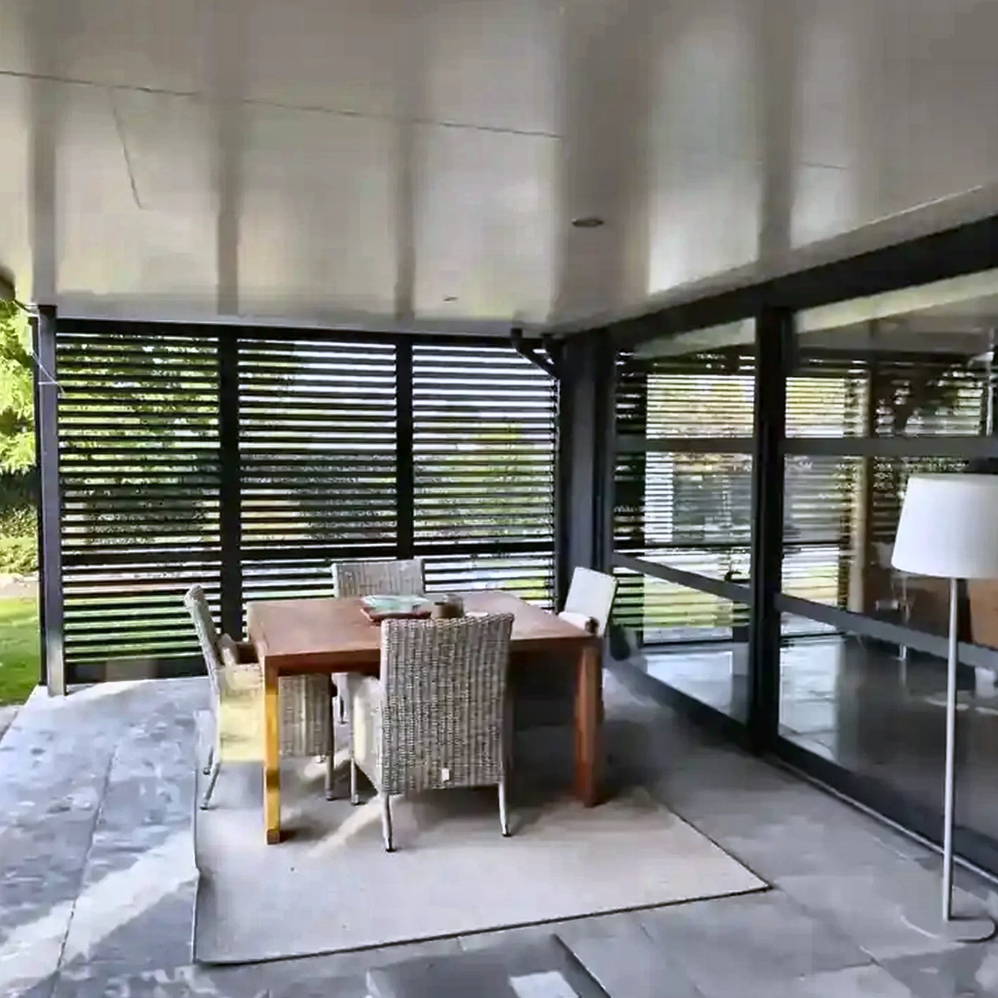 Zwarte aluminium shutters bij een veranda