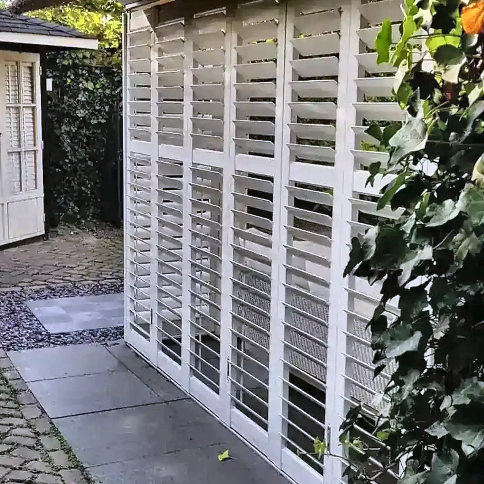 Witte aluminium shutters in een tuinopstelling