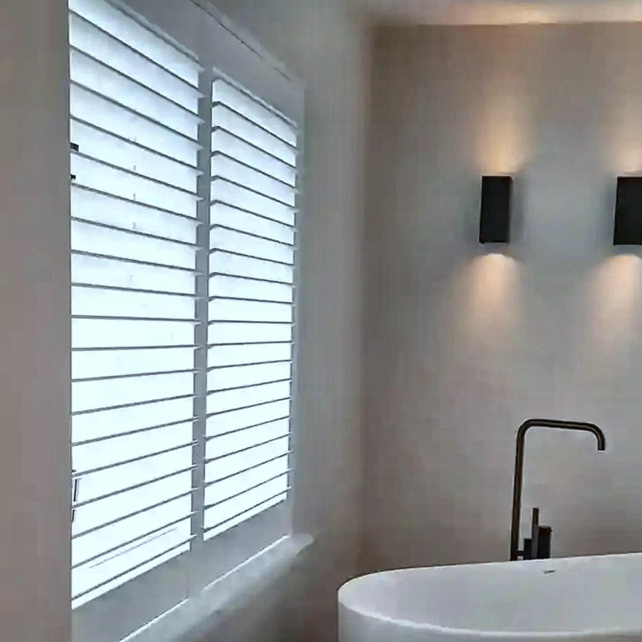 Witte shutters naast een vrijstaand bad
