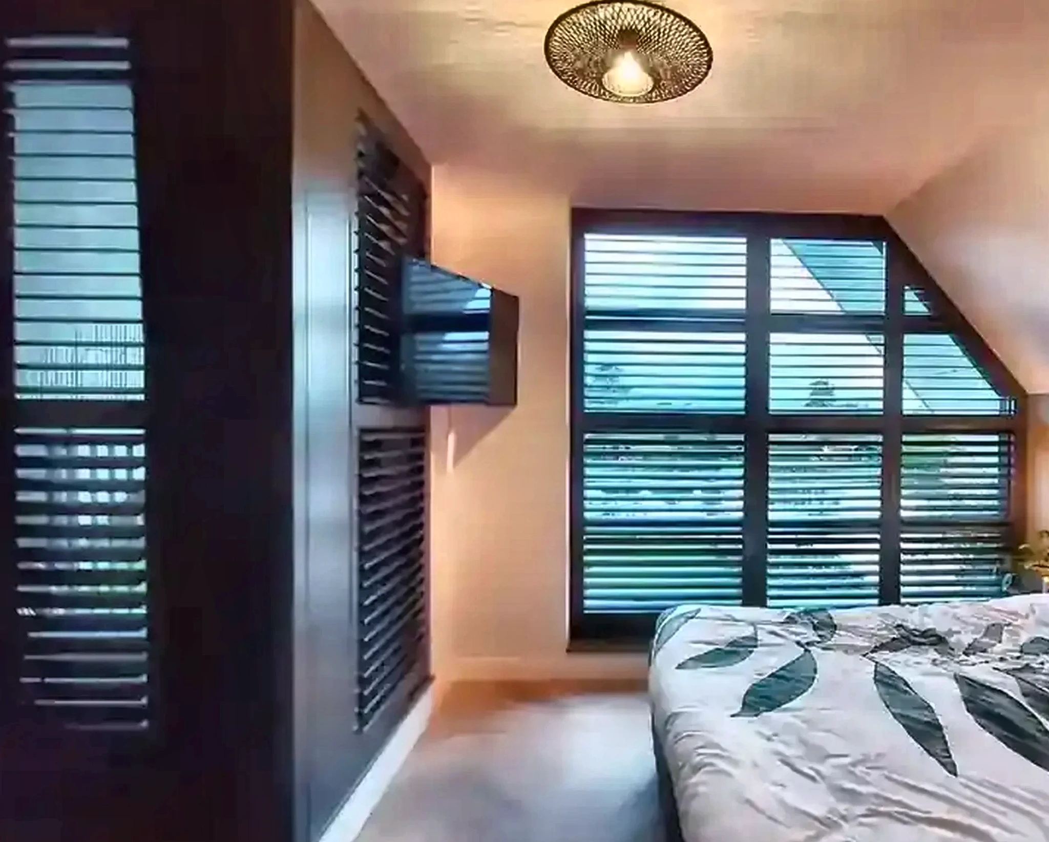 Zwarte shutters in een slaapkamer met puntvorm