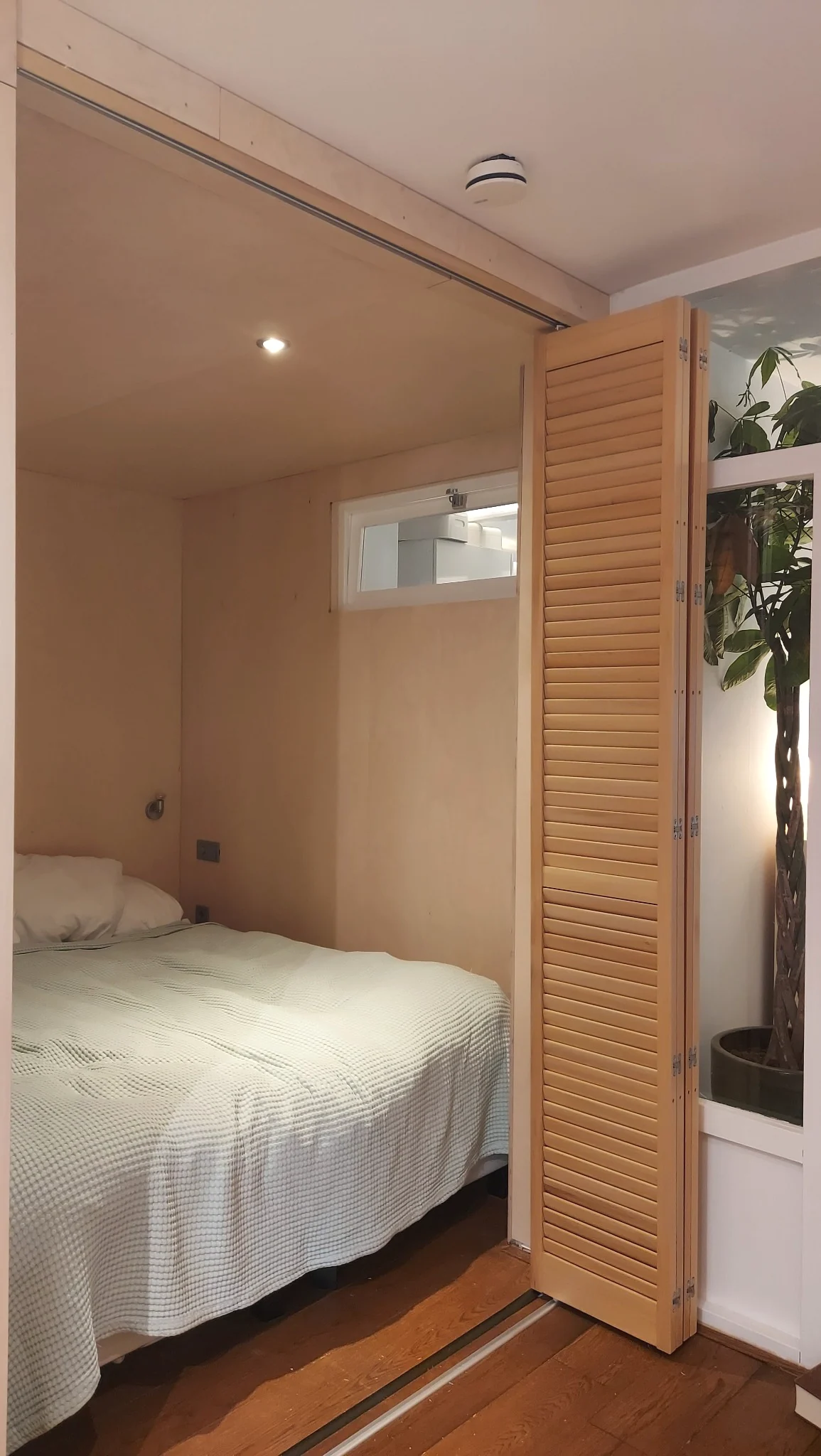 Sandblasted shutters geopend als slaapkamerafscheiding in Amsterdam