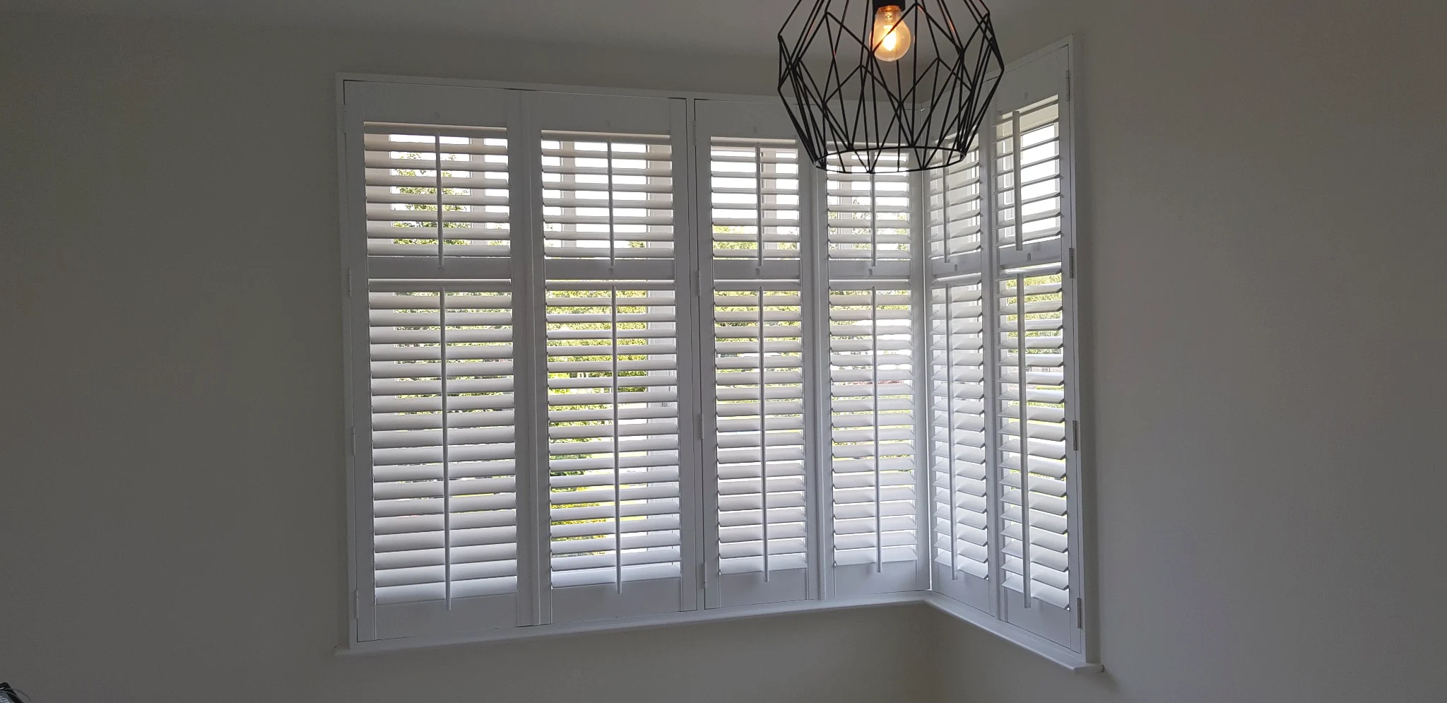 Witte shutters in een hoekraam in Bavel