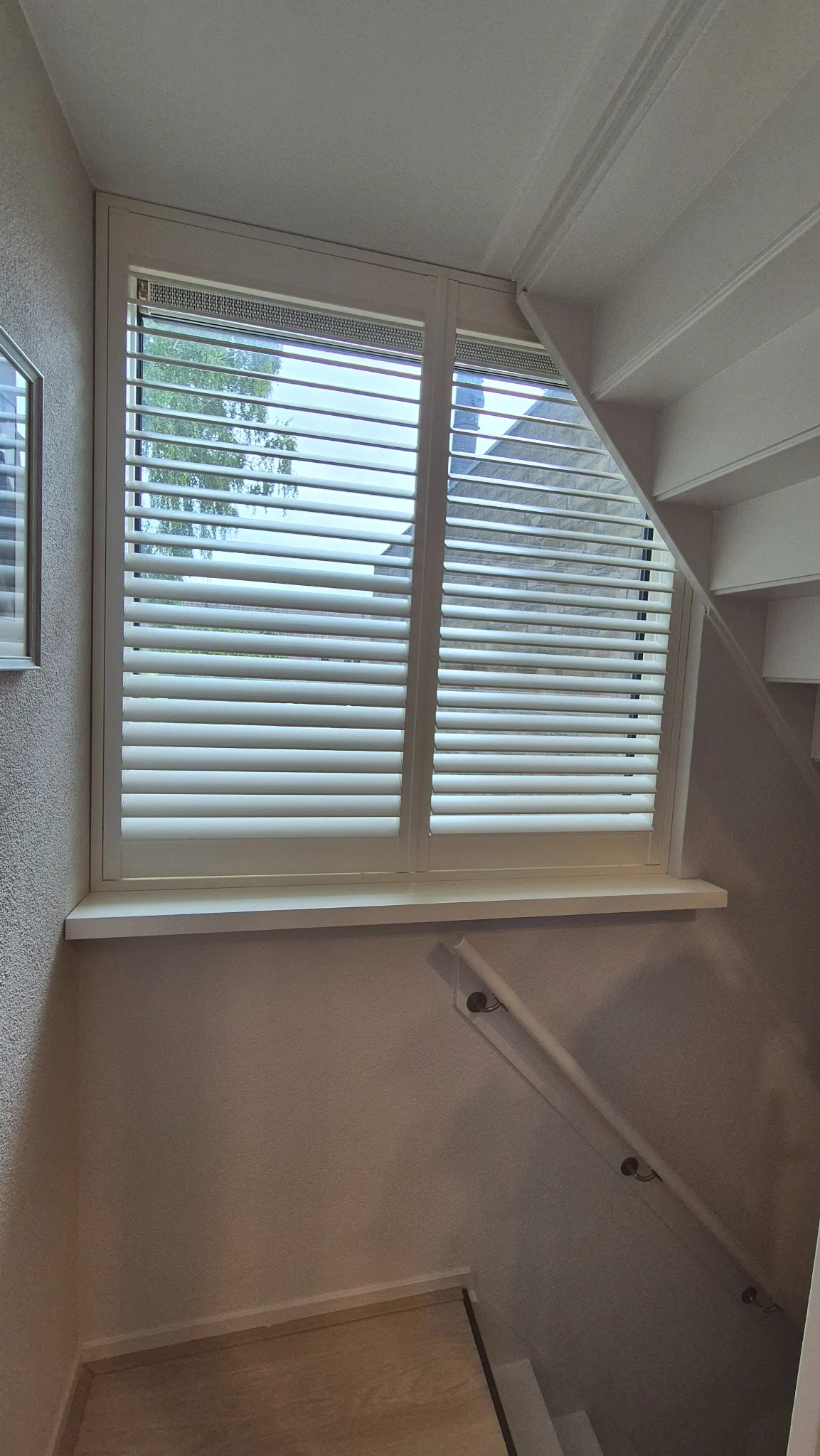 Witte shutters achter een trap in Drunen