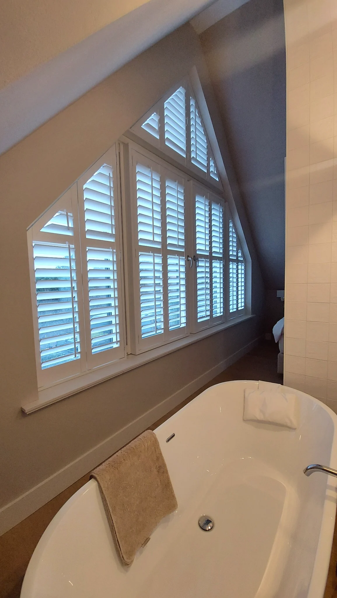 Witte shutters naast een vrijstaand bad in Huizen